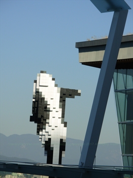 Side profile of the Digital Orca sculpture with mountains behind it