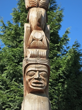 Lower baseline detail of the woman figure holding lahal bone game crest profiles