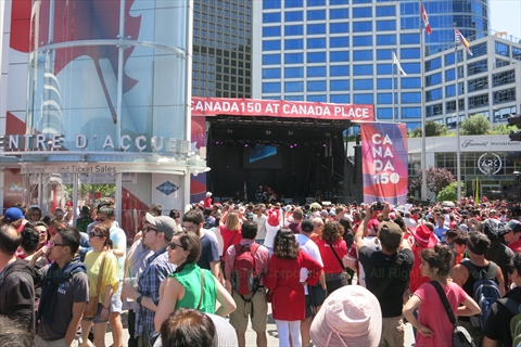 Festive crowds with Canadian flags celebrating Canada Day at Canada Place, Vancouver, Canada