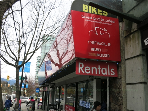 Rows of rental bikes lined up outside the Bikes and Blades storefront on Denman Street