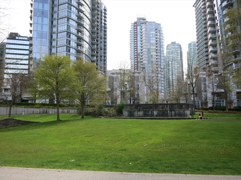 Wide open grass lawns of Harbour Green Park framing views of the north shore mountains
