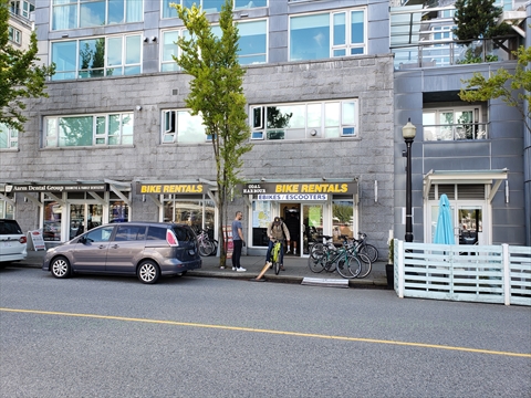 Waterfront storefront facade of Coal Harbour Bike Rentals along the quay promenade