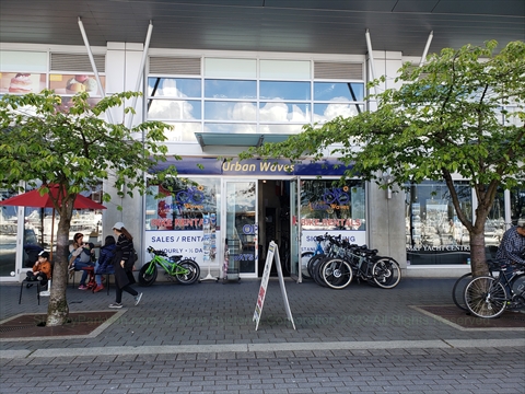 Rental hybrid bikes aligned inside the Urban Wave storefront along the promenade