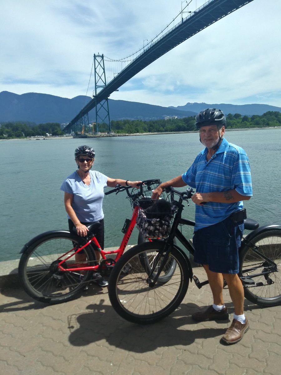 Bicyclists under the Lions Gate Bridge in Stanley Park, Vancouver, BC, Canada